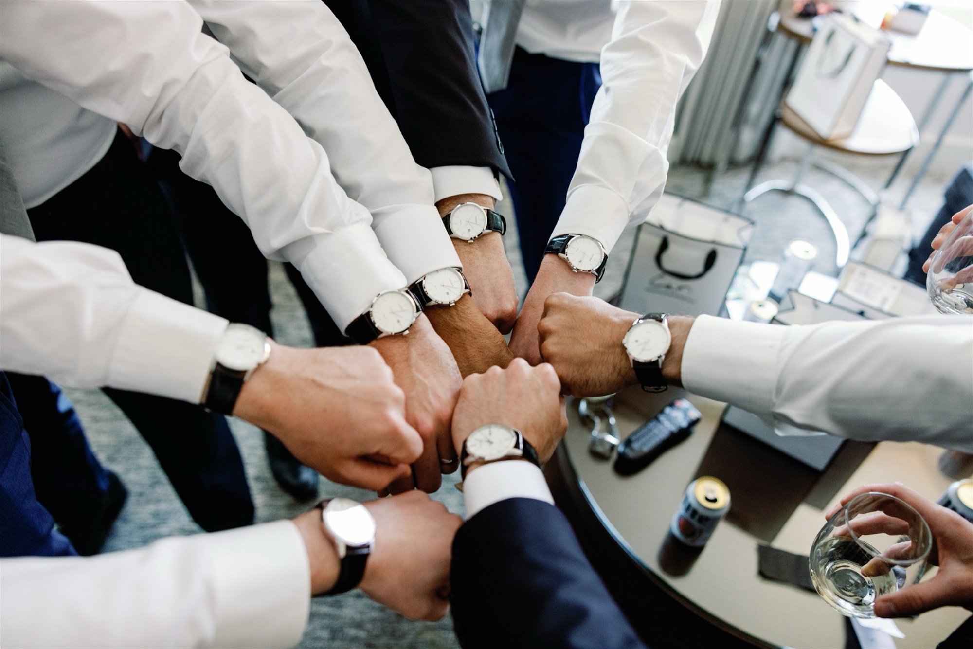 Groomsmen put their hands together to show off watches gifted by the groom.